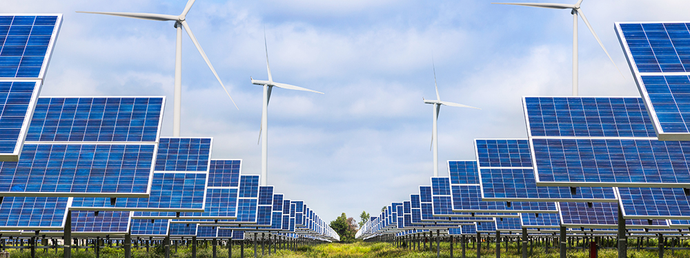 Symmetrische Aufnahme von Solarfarm mit Windrädern im Hintergrund