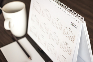 Tischkalender von oben neben Tasse und Papier mit Tisch